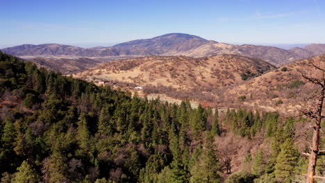 The-evergreen-forest-on-the-Tehachapi-mountains-transitions-into-the-arid-landscape-of-the-Mojave-Desert---aerial-view