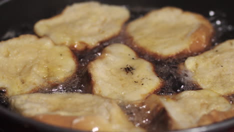 Golden-round-pieces-of-old-bread-frying-on-hot-skillet-to-make-Rabanadas---Close-up