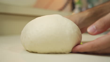 Baker-shaping-and-sliding-silky-smooth-bread-dough-over-the-counter