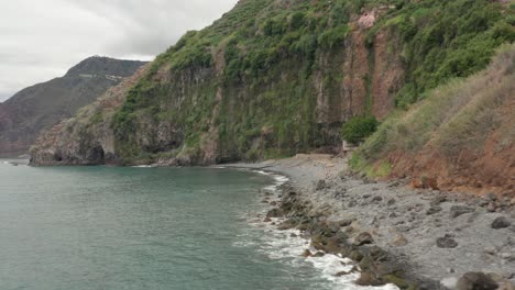 Abgelegener-Basaltkieselstrand-Praia-Dos-Anjos-Mit-Einheimischen,-Die-Sich-An-Der-Küste-Entspannen