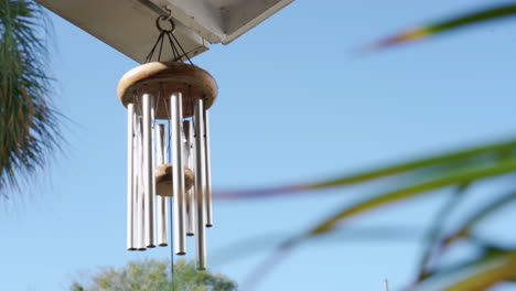 Calming-and-relaxing-view-of-a-wind-chime-blowing-in-a-tropical-garden