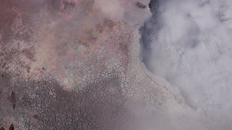 Aerial-at-active-volcanic-mud-pool-bubbling-wildly-with-steam,-Gunnuhver-geyser