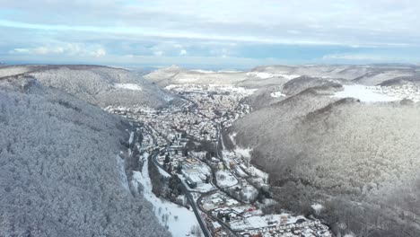 Erstaunlicher-Luftflug-In-Richtung-Schneebedecktes-Dorf-Honau-Und-Wald-Mit-Blauem-Himmel-Im-Winter-In-Schwaben,-Deutschland