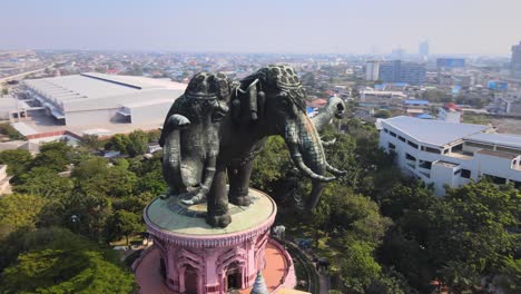 4k-Aerial-Erawan-Museum-at-highway,-BTS-Skytrain-goes-over-a-bridge-in-Samut-Prakan-Province,-Thailand