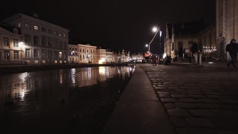 Static-low-angle-from-Graslei-of-Leie-River-with-lantern-reflection-in-water-and-Korenlei-in-background-during-night
