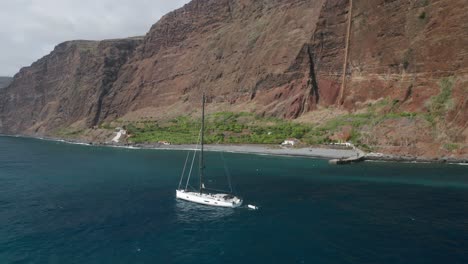 Sailboat-floats-peacefully-in-blue-water-of-Atlantic-Ocean-near-shore-of-Madeira
