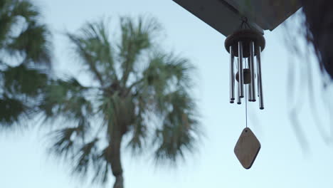 Calming-and-relaxing-view-of-a-wind-chime-blowing-in-a-tropical-garden