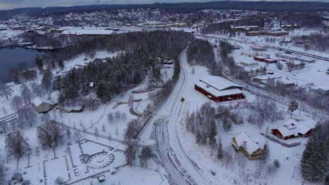 Drone-footage-orbiting-over-a-cemetery-while-a-tractor-clearing-the-street-from-snow