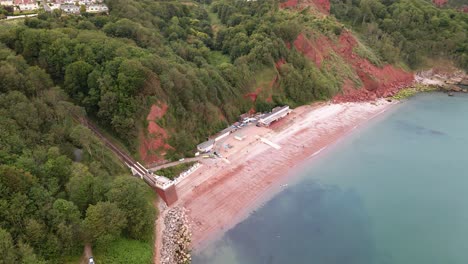 Aerial-top-down-shot-of-famous-oddicombe-beach-with-overgrown-cliffs-and-cable-car-in-Torquay,England