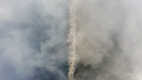 Felswand-Ist-Zwischen-Dichtem-Nebel-In-Den-Bergen-Sichtbar,-Von-Oben-Nach-Unten-Aus-Der-Luft