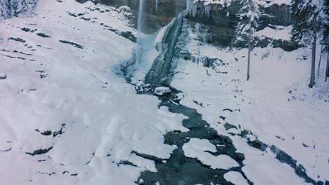 A-Close-up-Aerial-View-of-the-Cascade-du-Rouget-covered-in-snow-during-winter,-French-Alps