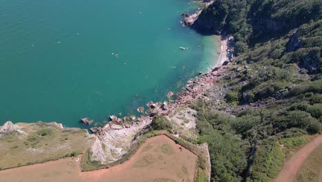 Aerial-top-down-shot-of-long-Quarry-View-point-and-steep-cliff-slope-with-clear-blue-water-in-the-valley