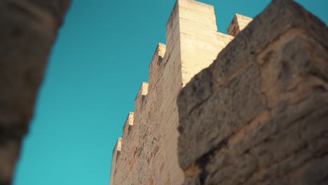 Portugal-Loule-Steinmauer-Enthüllt-Burgmauerzinnen-In-Lkw-kamerabewegung-Unter-Blauem-Himmel-4k