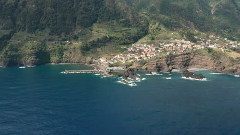 Remote-island-village-Seixal-on-steep-volcanic-shore-of-Madeira,-aerial