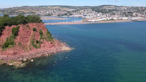 Aerial-orbiting-shot-of-ness-cove-cliffs-and-babbacombe-bay-during-sunny-day-with-blue-sky-in-Shaldon,England