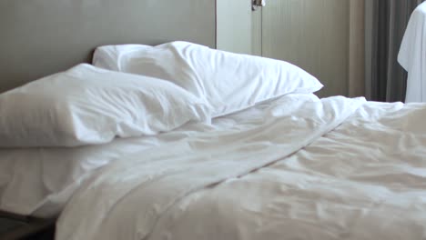 Housekeeper-is-making-the-bed-in-the-room--place-pillow-into-the-bed