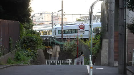 Subway-Train-Running-Across-The-Railway-With-Skylines-At-Background-In-Tokyo,-Japan