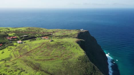 Aerial-of-green-cliffs-above-blue-Atlantic-water-with-Ponta-do-Pargo-Lighthouse