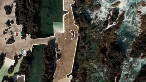 Top-down-aerial-of-natural-swimming-pools-between-rocky-shore-of-Porto-Moniz