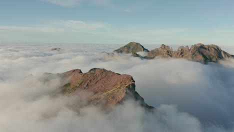 Majestic-mountain-peaks-of-Madeira-above-white-fluffy-clouds-with-sunshine