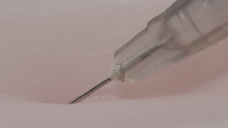Macro-view-of-a-syringe-penetrating-human-skin-as-a-patient-receives-a-vaccination