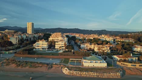 Aerial-sunset-view-of-apartment-and-hotel-resorts-near-the-shoreline,-tracking-left,-at-Marbella,-Andalusia,-South-of-Spain