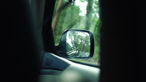 Right-Side-Mirror-View-Of-A-Car-Driving-In-The-Forest,-POV,-slow-motion