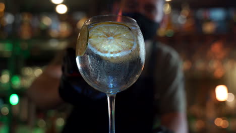 Barkeeper-Flammendes-Rauchen-Rotierender-Zitruswodka-Tonic-Nachtbar-Hintergrund