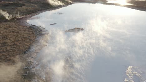 Steam-rises-from-acidic-volcanic-lake-in-Iceland,-evaporation-process