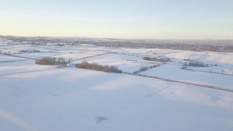Ungestörte-Winterlandschaft-Mit-Einem-Haus-Und-Feldern,-Die-An-Einem-Hellen,-Kalten-Tag-In-Schottland-Während-Der-Goldenen-Stunde-Bis-Zum-Horizont-Mit-Weißem-Schnee-Bedeckt-Sind