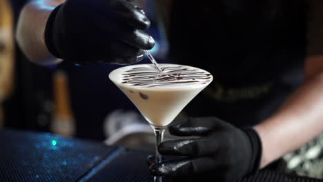 Bartender-decorating-top-cocktail-with-liquid-chocolate
