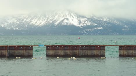 South-Lake-Tahoe-during-winter-with-a-pier-in-the-middle-and-beautiful-snow-capped-mountains-in-the-background