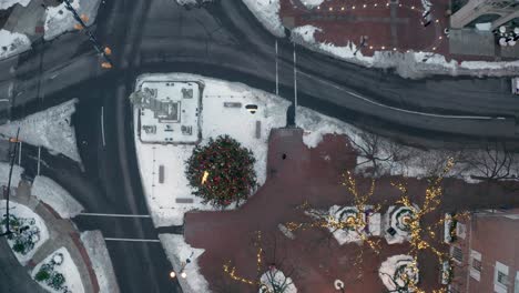 Descending-top-down-aerial-of-decorated-Christmas-tree-and-lights-in-downtown-city