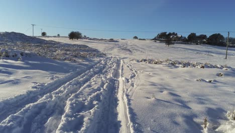 Schneebedeckte-Ländliche-Winterlandschaft-Spur-Fußabdruck-Schatten-Gelände-Luftbild-Folgenden-Spuren