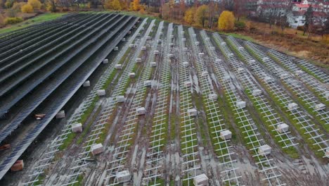 Aerial-view-of-solar-panel-farm-on-a-green-field-in-the-countryside,-fly-over-shot