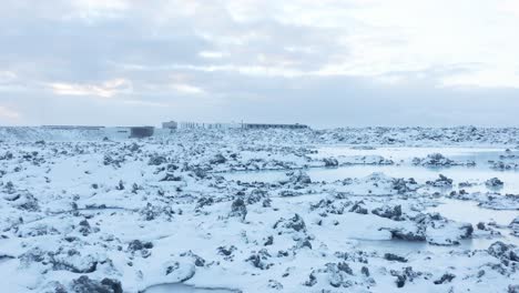 Volcanic-rocks-covered-in-white-snow-outside-of-Blue-Lagoon-resort,-Iceland