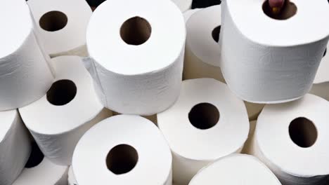 Panning-shot-of-toilet-paper-stacked-onto-pile