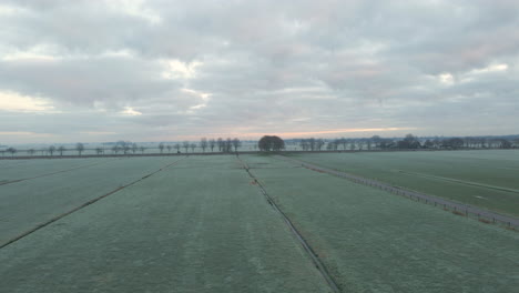 Aerial-of-frost-covered-rural-landscape-at-dawn