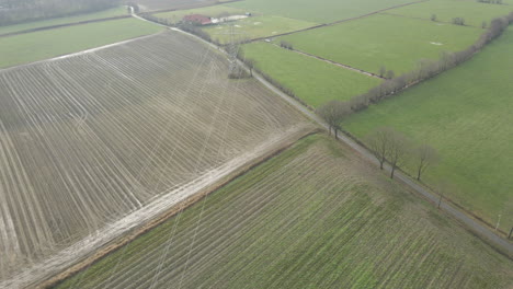 Aerial-of-power-lines-running-over-meadows-in-countryside