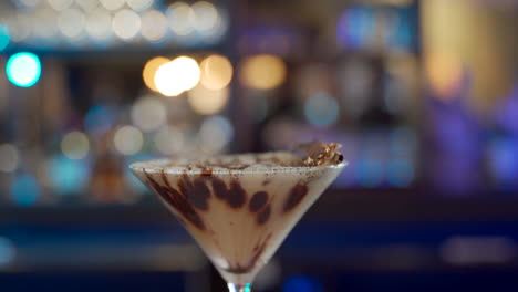 sweat-cocktail-cinnamon-chocolate-rotating-in-bar-blurry-background