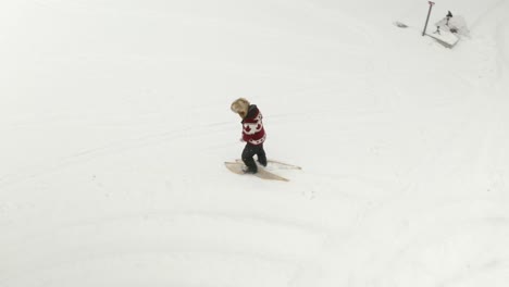 Hombre-Adulto-Con-Un-Gran-Sombrero-De-Piel,-Camina-Y-Juega-Con-Raquetas-De-Nieve-Tradicionales-En-Un-Lago-Congelado-Con-Sus-Perros-En-El-Norte-De-Canadá