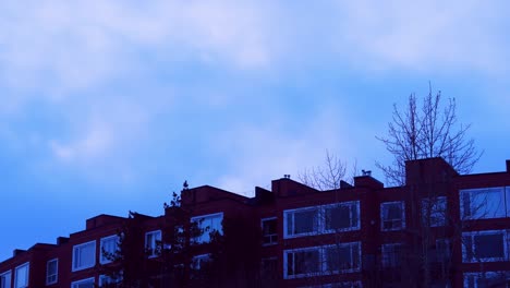 4k-Super-Smooth-Zoom-Closeup-Time-Lapse-of-Twilight-Burgundy-cliffside-condo-development-forty-five-degree-perspective-with-popping-blue-skies-and-cloud-formation-moving-upwards-on-a-winter-cold-day