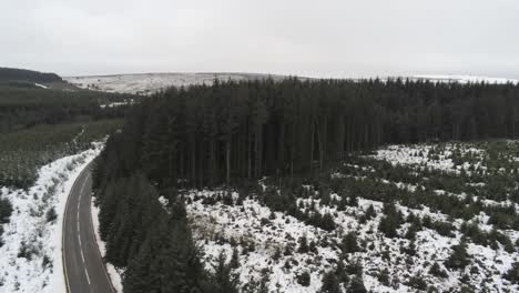 Dolly-Rechts-Zur-Schneebedeckten-Geschwungenen-Winterwaldstraße-Luftaufnahme-Nach-Waldbaumlandschaft