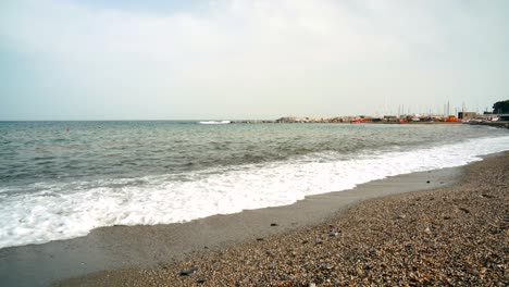 Playa-De-Liguria-Formada-Por-Guijarros,-Vista-Desde-Abajo-Donde-Las-Olas-Rompen-En-La-Playa-De-Guijarros,-Varazze,-Liguria-Italia