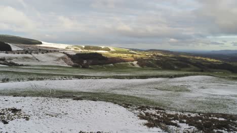 Snowy-idyllic-rural-winter-valley-countryside-aerial-agricultural-farmland-landscape