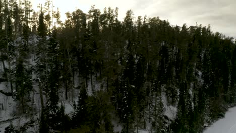Luftaufnahme-Der-Untergehenden-Sonne-Hinter-Dem-Winterlichen-Borealen-Wald-Im-Norden-Kanadas