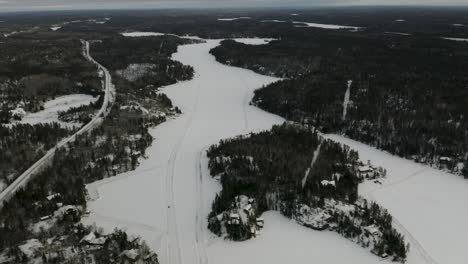 Ice-roads-scattered-throughout-the-frozen-lake-hidden-among-the-boreal-forest-in-northern-Canada