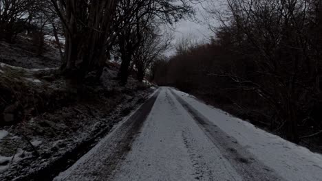 Driving-snowy-frozen-rural-country-road-in-slippery-winter-conditions-on-frosty-morning