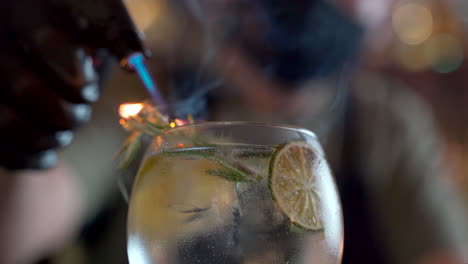 Barkeeper-Nahaufnahme-Flammende-Rosmarin-Zitrus-Wodka-Tonic-Cocktail-Flamme