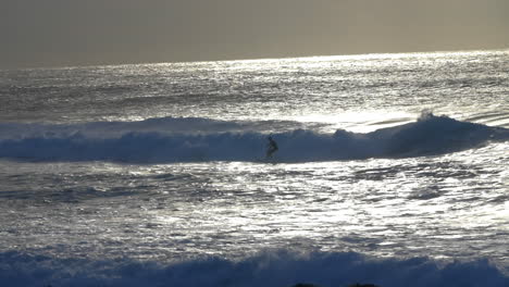 Silhouette-Of-Surfer-Surfing-In-Ocean-At-Sunrise-From-Bronte-Beach-In-Sydney,-NSW,-Australia